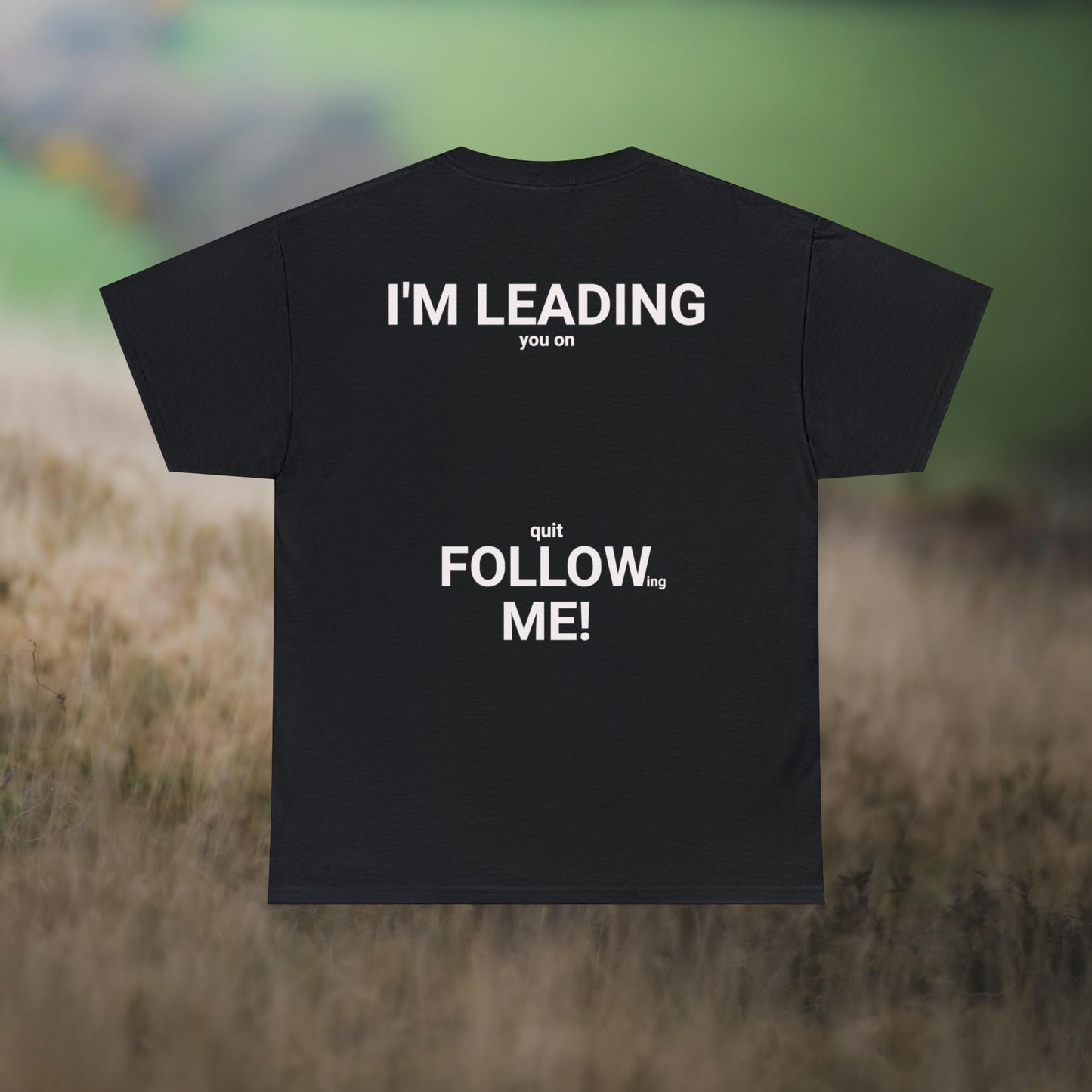 Black tee's back, with graphic "I'm leading you on, quit following me!" on a field background.