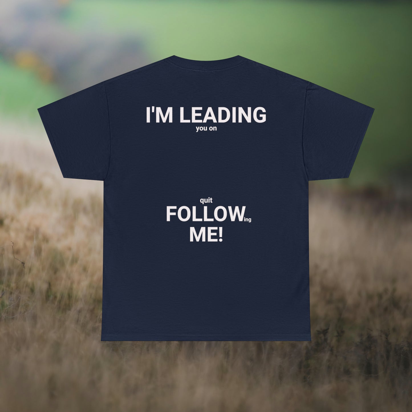 Blue tee's back, with graphic "I'm leading you on, quit following me!" on a field background.