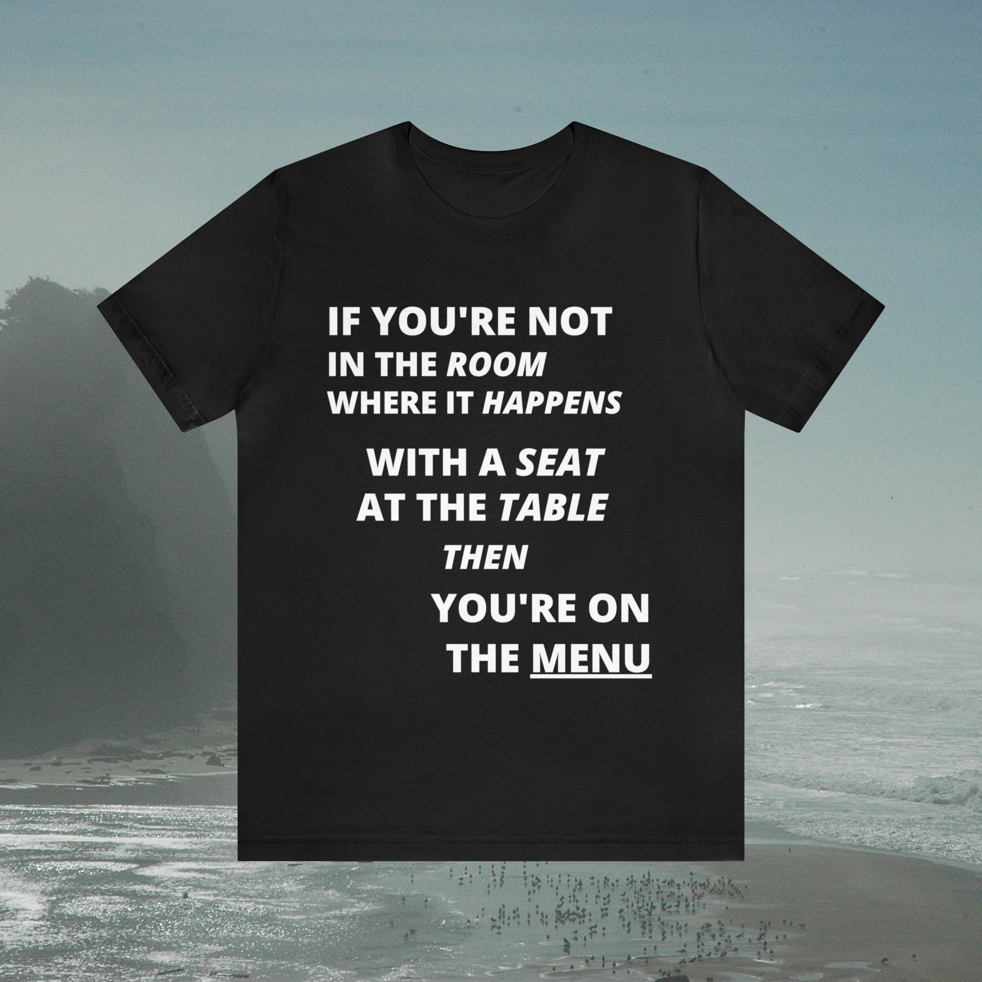 Black tee with graphic "If you're not in the room...", foggy seashore background.