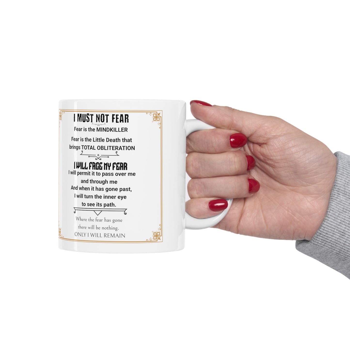 Dune's "Fear Litany" on a white mug being held by a hand with red fingernails