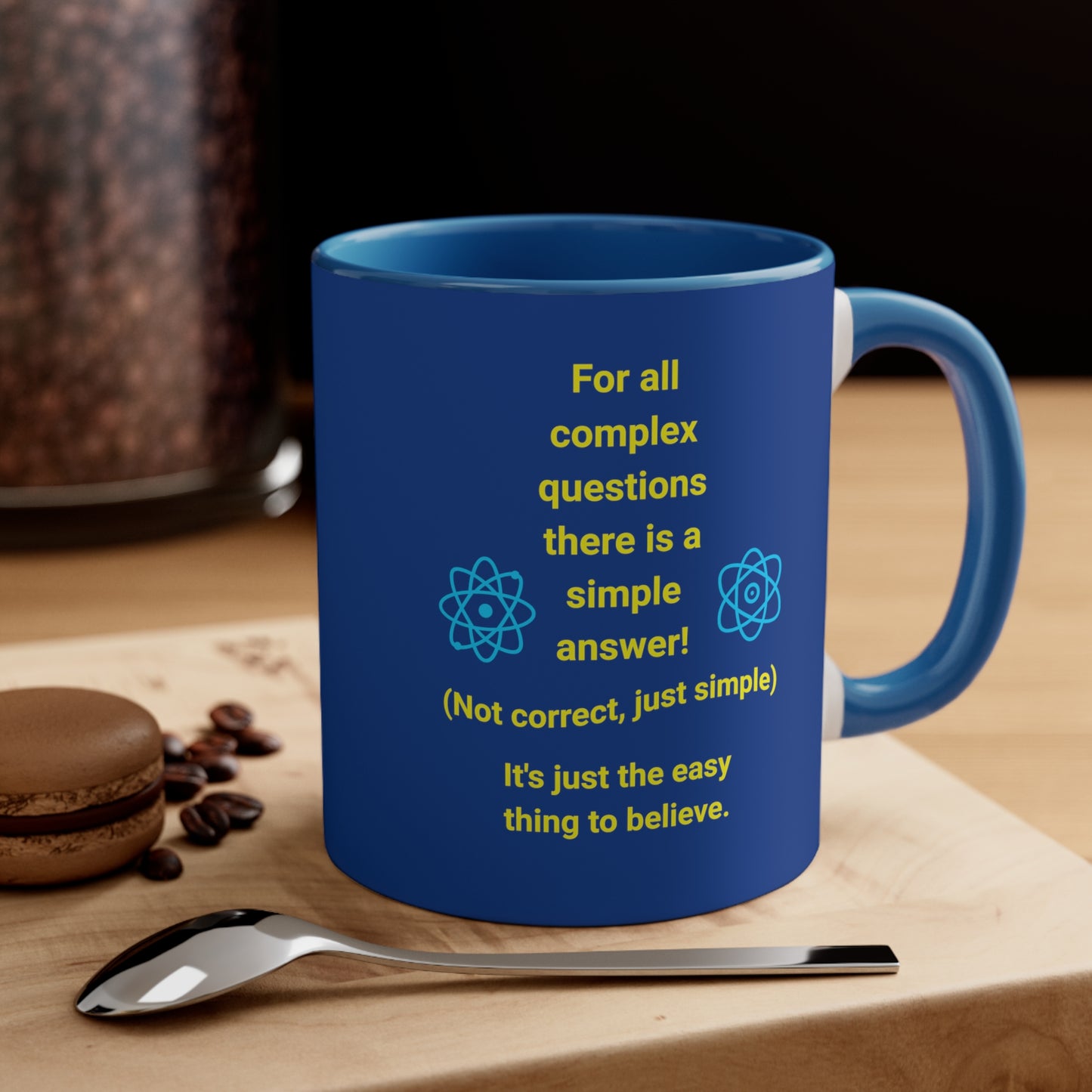 Navy blue mug with blue handle and inside, with quote "Complex Questions" on a woodblock with spoon and cookie