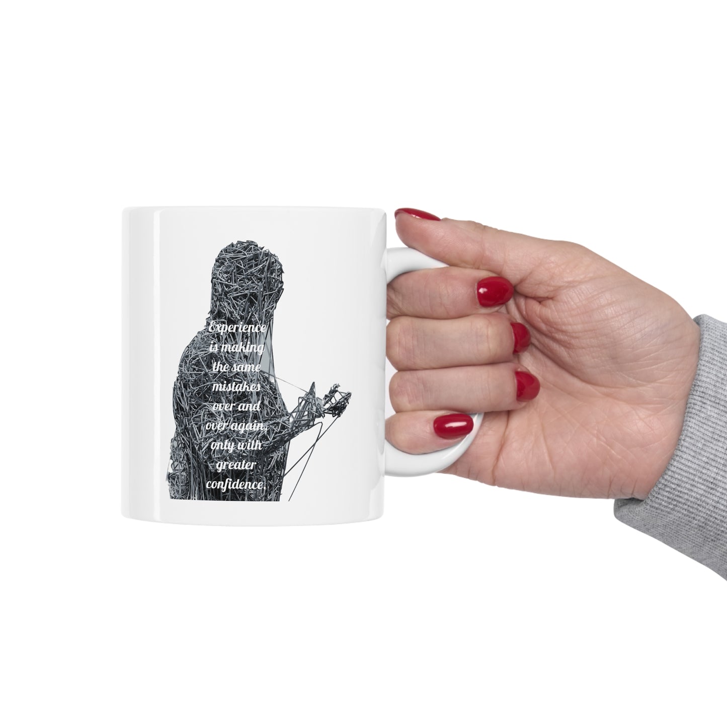 Hand holding graphic "Experience is making the same mistakes" monster on white mugs.