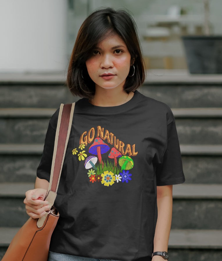 Young woman wearing black graphic tee with "Go Natural", standing in front of steps