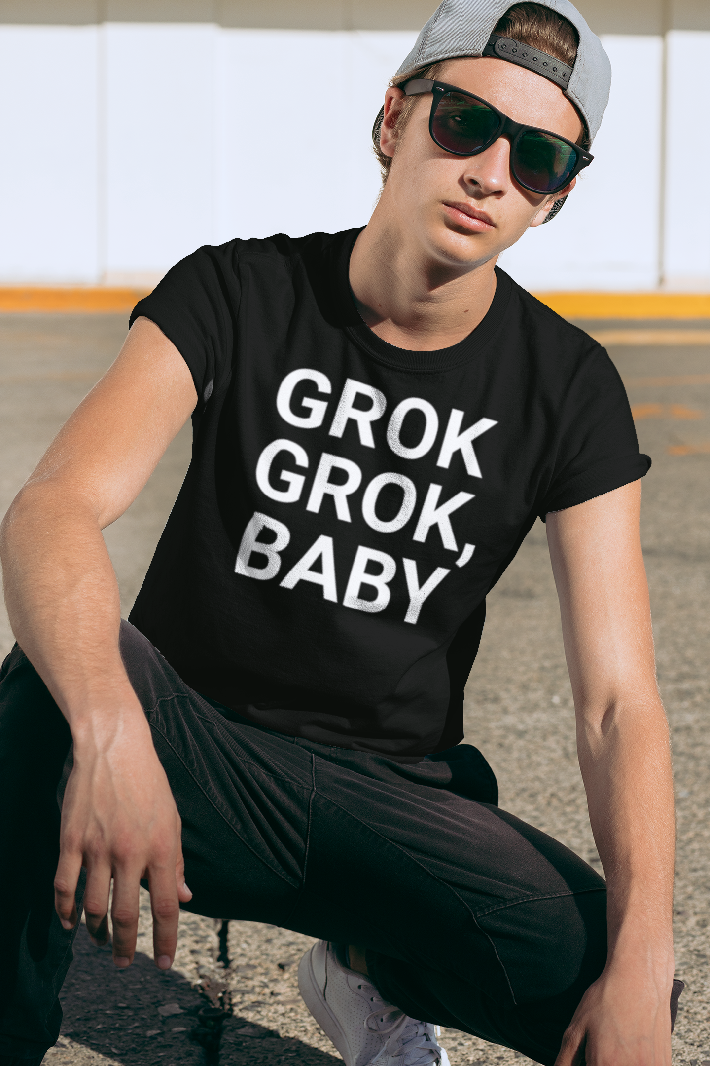 Young man with sunglasses wearing black tee with "Grok Grok, Baby!"