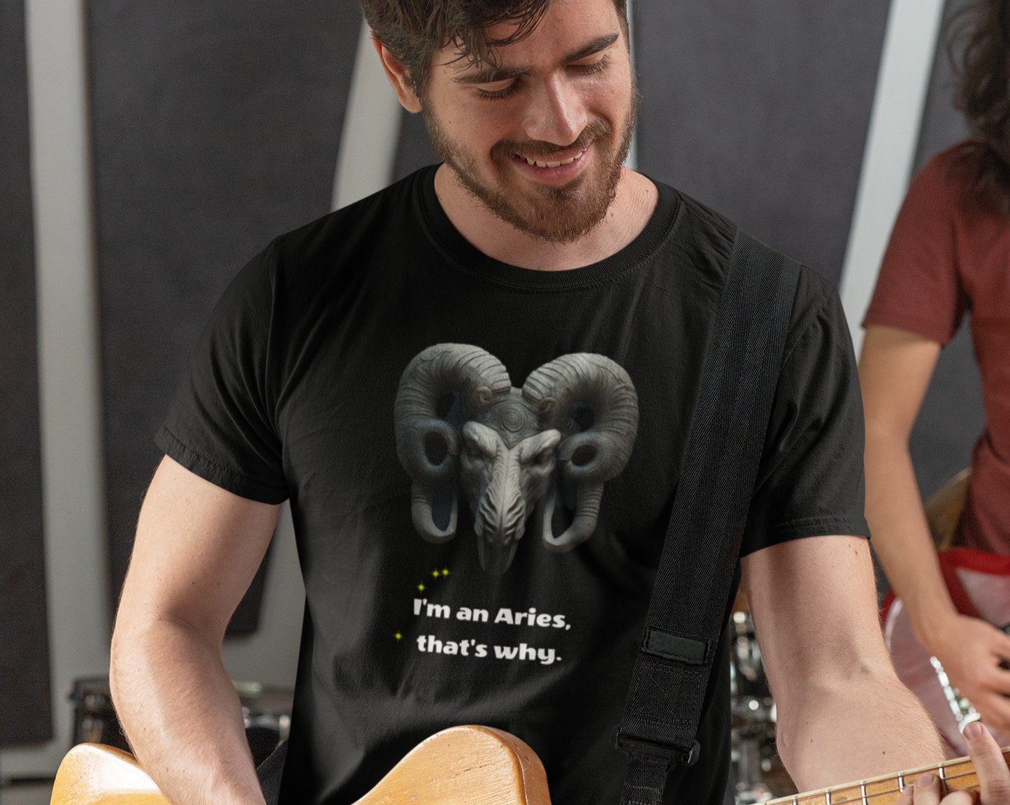 Man playing guitar while wearing a black tee with graphic "I'm an Aries, that's why."