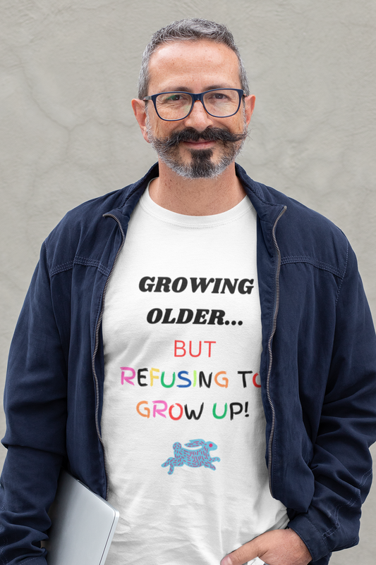 Middle aged man with laptop in a white Tee with graphic "Growing older, but..."