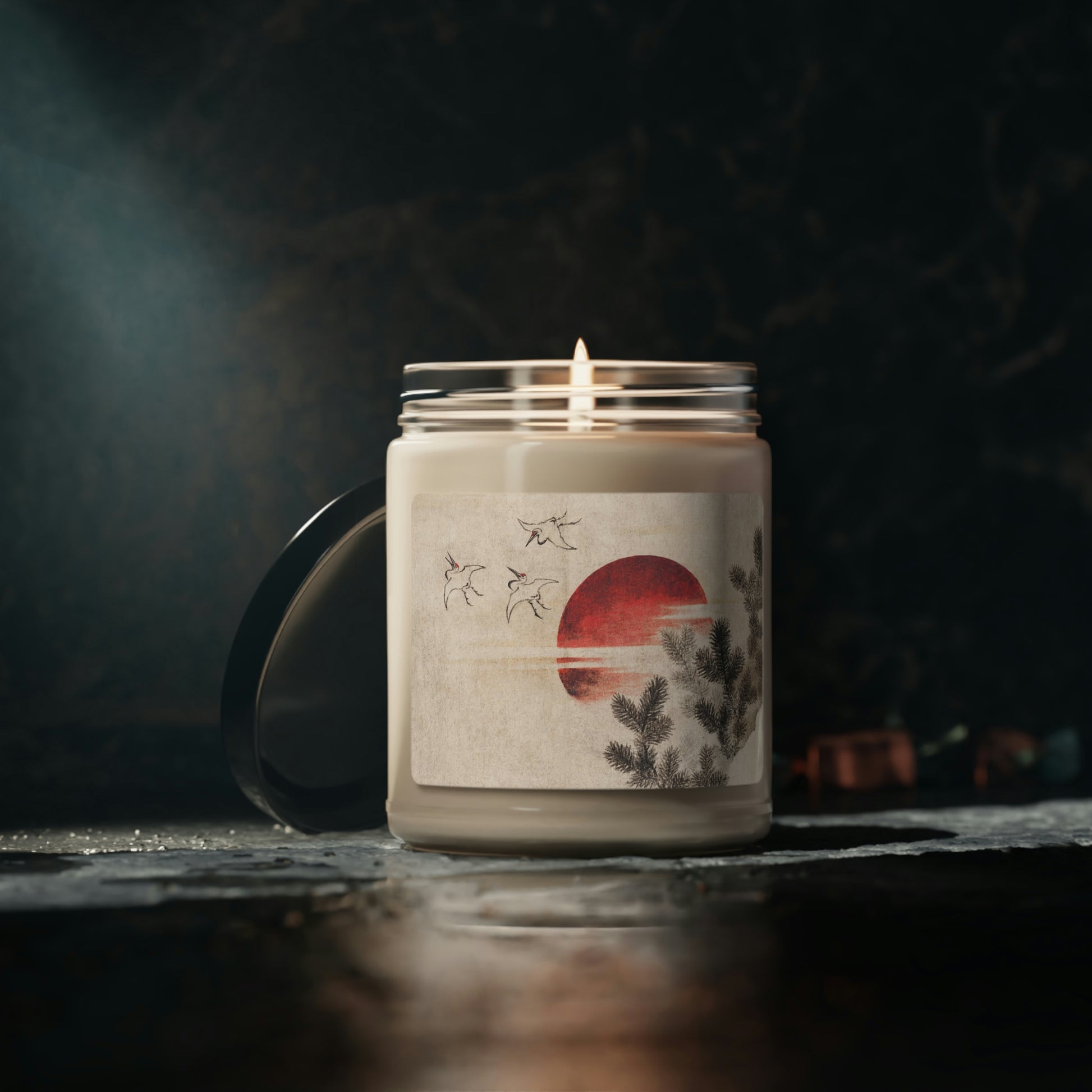 "Clean Cotton" Scented Soy Candle  jar with Hokusai print 'birds and sunset', lit, with dark background and bare table